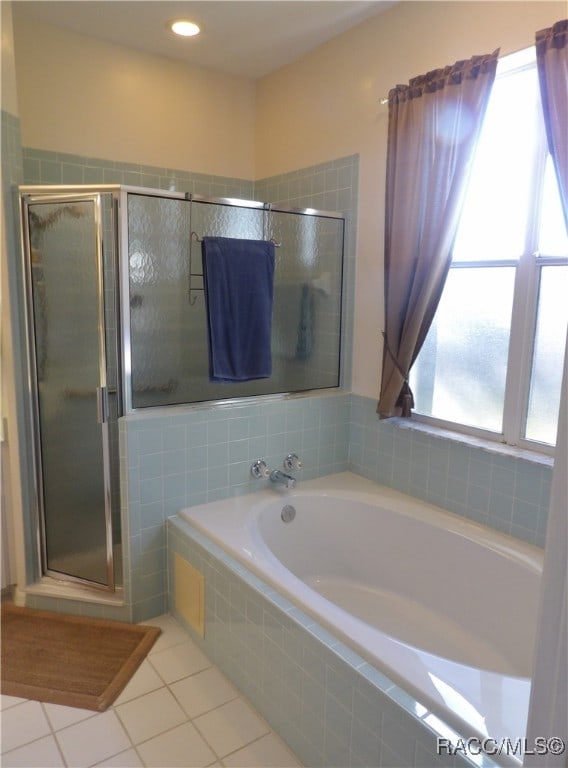 bathroom with shower with separate bathtub and tile patterned floors