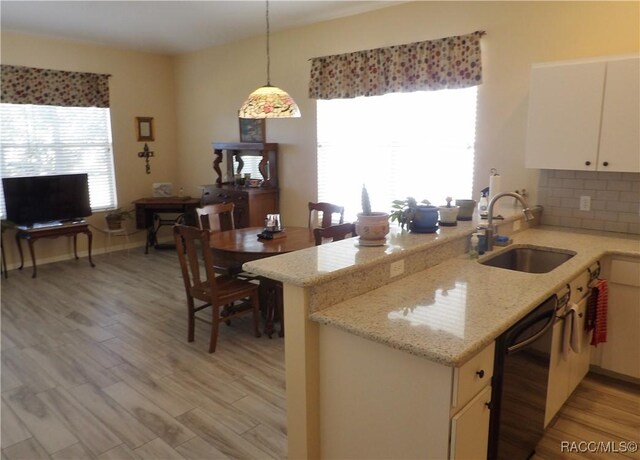 4614 N Crestline Dr, Beverly Hills, FL 34465 - kitchen featuring black dishwasher, light wood-style flooring, decorative light fixtures, tasteful backsplash, and light stone countertops