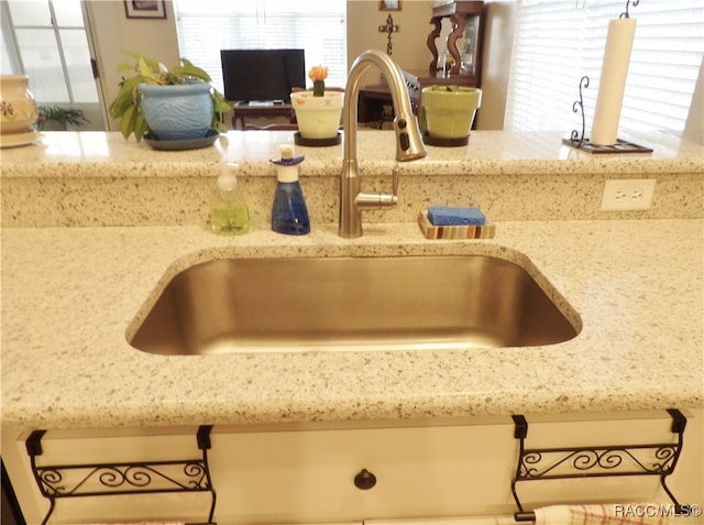 room details featuring light stone counters and sink