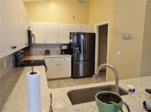 4614 N Crestline Dr, Beverly Hills, FL 34465 - kitchen featuring fridge with ice dispenser, stainless steel electric range, tasteful backsplash, white cabinets, and light stone counters