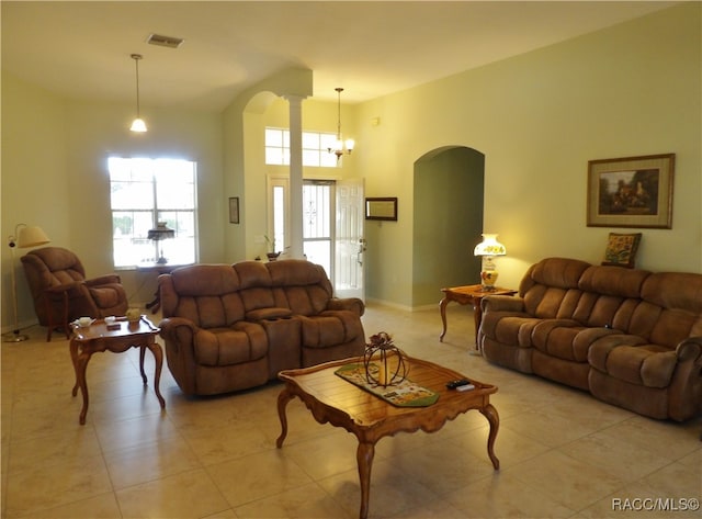 tiled living room with a notable chandelier and decorative columns