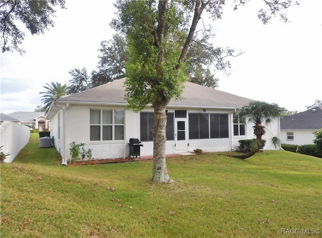 view of front facade with central air condition unit and a front lawn