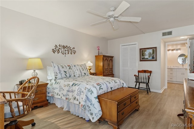 bedroom with ceiling fan, light wood-type flooring, connected bathroom, and a closet