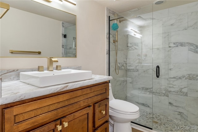 bathroom with vanity, an enclosed shower, and toilet