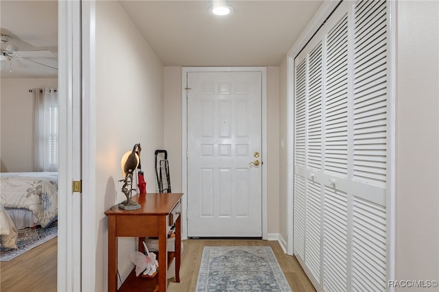 doorway with ceiling fan and light hardwood / wood-style floors