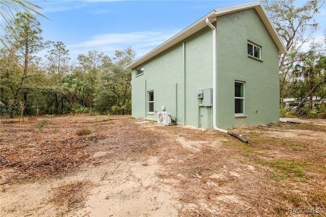 view of side of home with ac unit