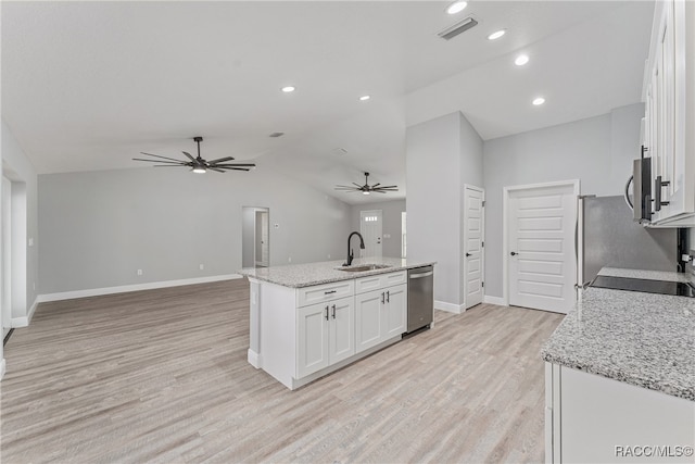 kitchen with appliances with stainless steel finishes, light stone counters, sink, a center island with sink, and white cabinets