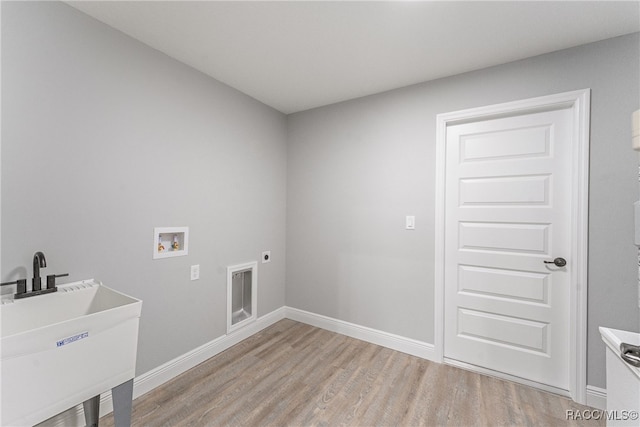 clothes washing area featuring washer hookup, light hardwood / wood-style floors, electric dryer hookup, and sink