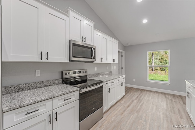 kitchen featuring white cabinets, light wood-type flooring, lofted ceiling, and appliances with stainless steel finishes