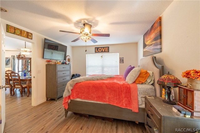 bedroom featuring ceiling fan, light wood-type flooring, and a textured ceiling