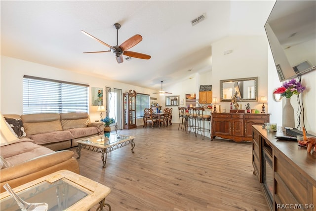 living room with ceiling fan, light hardwood / wood-style flooring, and high vaulted ceiling