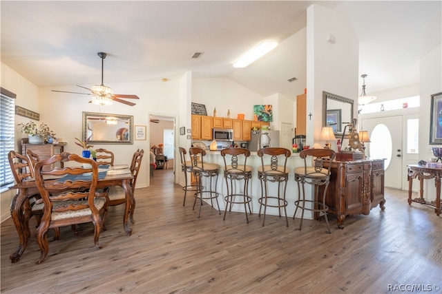 kitchen featuring kitchen peninsula, stainless steel appliances, ceiling fan, hardwood / wood-style flooring, and lofted ceiling