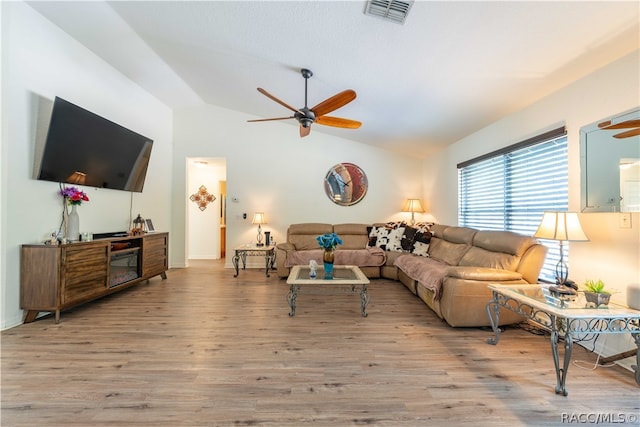 living room with light wood-type flooring, vaulted ceiling, and ceiling fan