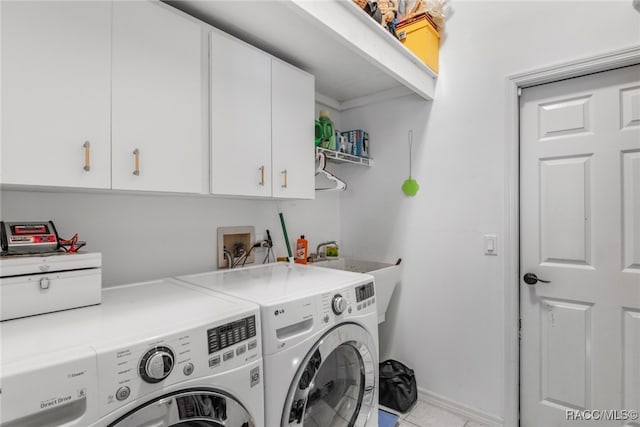 washroom with cabinets, light tile patterned flooring, and washing machine and clothes dryer