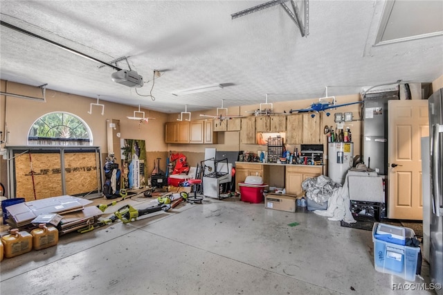 garage with a workshop area, a garage door opener, and water heater