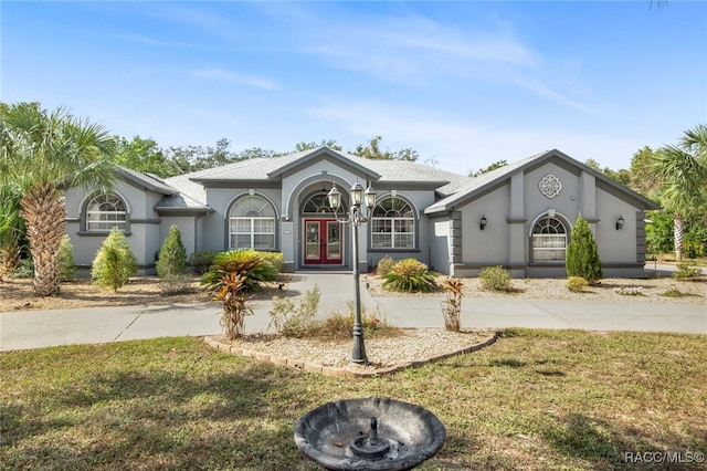 single story home featuring french doors and a front lawn