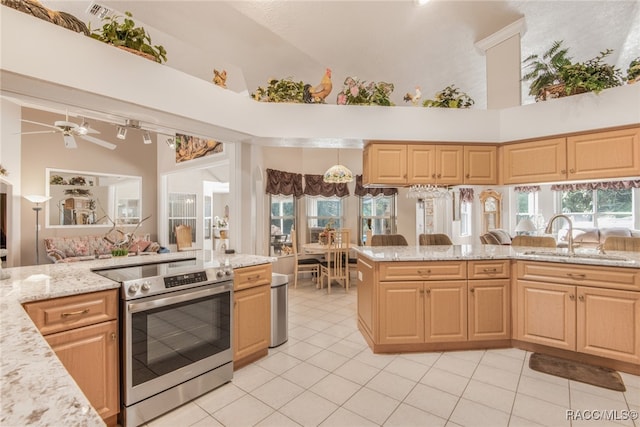 kitchen featuring light brown cabinetry, high vaulted ceiling, and stainless steel electric stove