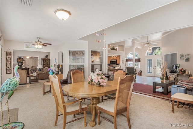 carpeted dining room with ceiling fan and french doors