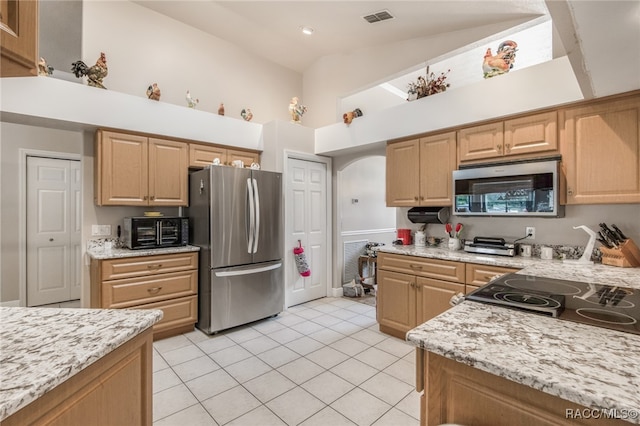 kitchen featuring high vaulted ceiling, light stone counters, light tile patterned floors, and appliances with stainless steel finishes