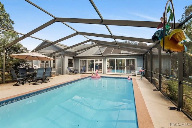 view of swimming pool with a lanai and a patio area