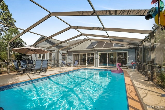 view of swimming pool featuring glass enclosure and a patio area