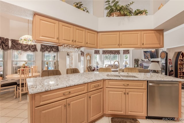 kitchen featuring sink, stainless steel dishwasher, a high ceiling, and light brown cabinets