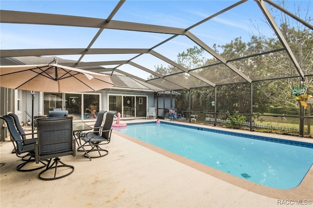 view of swimming pool featuring glass enclosure and a patio