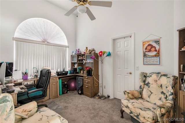 home office with light carpet, a high ceiling, and ceiling fan