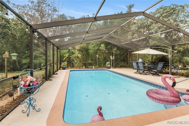 view of pool featuring glass enclosure and a patio