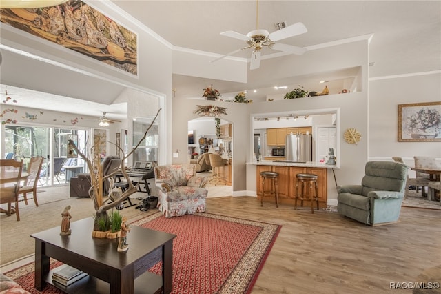 living room featuring light hardwood / wood-style flooring, ceiling fan, and ornamental molding