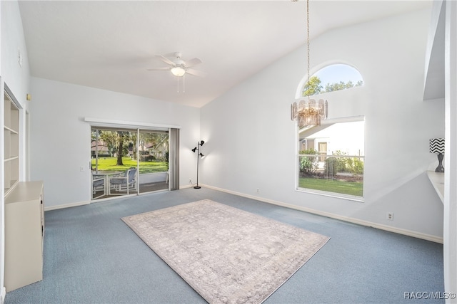 carpeted living room with ceiling fan with notable chandelier and high vaulted ceiling