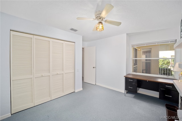 home office with carpet flooring, ceiling fan, and a textured ceiling