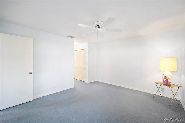 carpeted spare room with ceiling fan