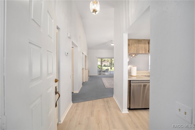 hall with light hardwood / wood-style floors and vaulted ceiling