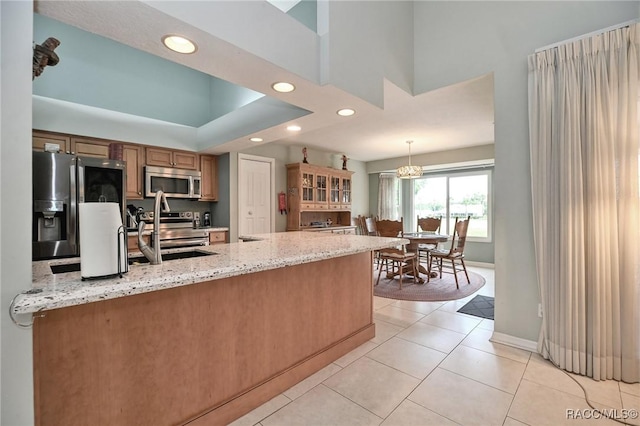 705 E Dakota Ct, Hernando, FL 34442 - kitchen featuring appliances with stainless steel finishes, recessed lighting, a peninsula, light stone counters, and light tile patterned floors