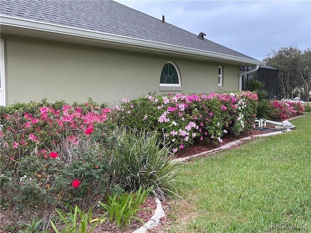 705 E Dakota Ct, Hernando, FL 34442 - view of side of property with stucco siding, a shingled roof, and a yard