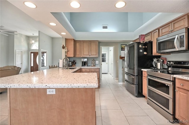 705 E Dakota Ct, Hernando, FL 34442 - kitchen featuring appliances with stainless steel finishes, a sink, light tile patterned floors, a peninsula, and a tray ceiling