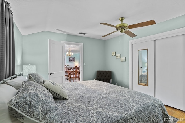 bedroom with a closet, hardwood / wood-style flooring, ceiling fan, and lofted ceiling