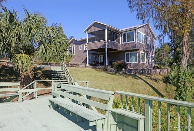 back of house with a sunroom and a yard