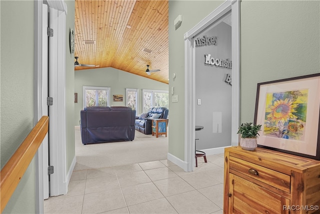 hall featuring light tile patterned floors, wooden ceiling, and vaulted ceiling