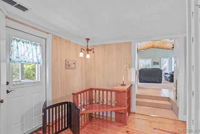 interior space featuring hardwood / wood-style floors, vaulted ceiling, and a notable chandelier