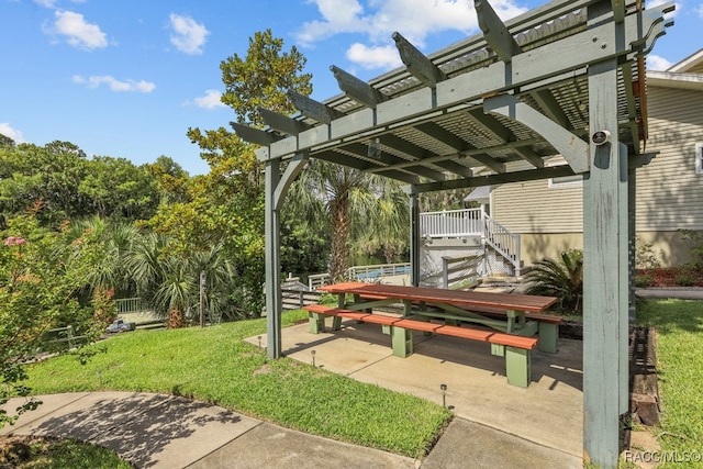 view of property's community featuring a lawn, a pergola, and a patio