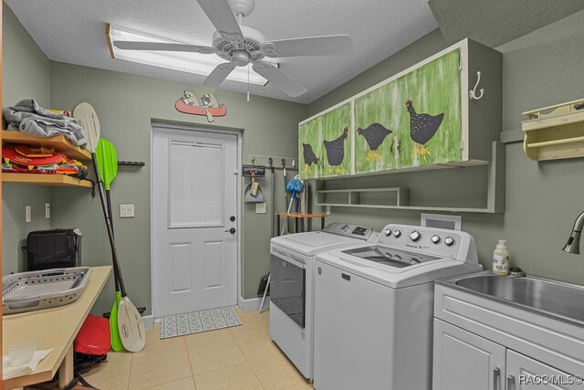 clothes washing area featuring washer and dryer, a textured ceiling, ceiling fan, and cabinets