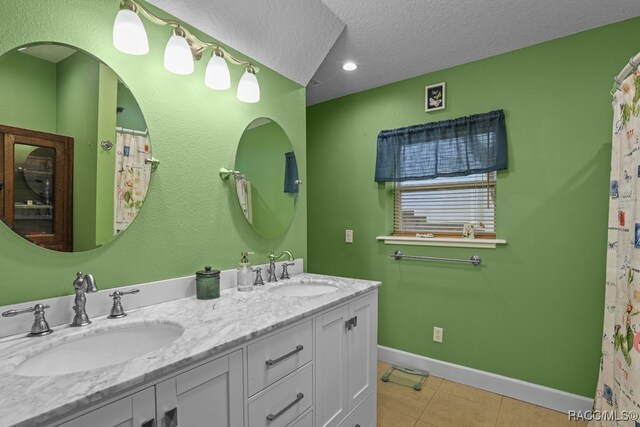 bathroom featuring tile patterned floors, vanity, and a textured ceiling