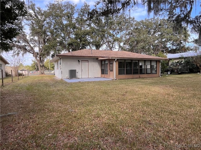 back of house featuring a sunroom, a patio area, a yard, and central air condition unit