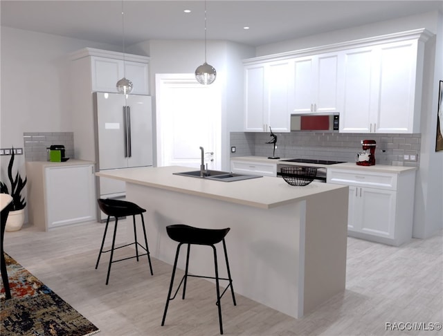 kitchen with white cabinets, decorative light fixtures, light wood-type flooring, and sink