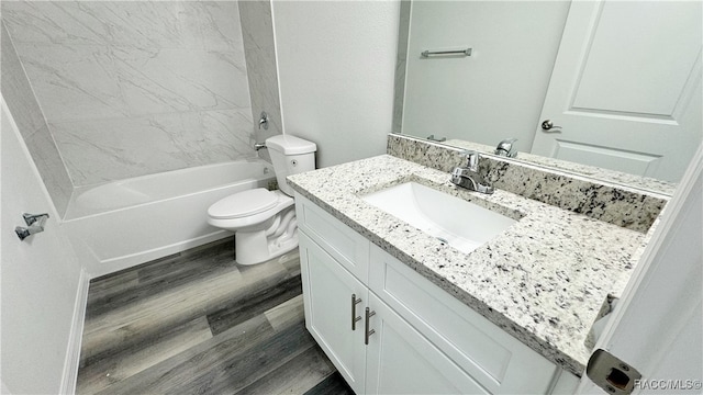 full bathroom with hardwood / wood-style floors, vanity, toilet, and tiled shower / bath