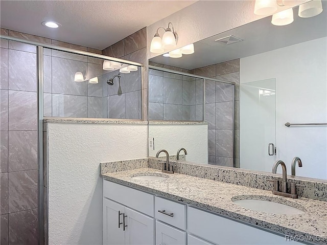 22777 SW Beach Blvd, Dunnellon, FL 34431 - full bath with double vanity, a stall shower, a textured ceiling, and a textured wall