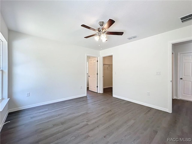 22777 SW Beach Blvd, Dunnellon, FL 34431 - unfurnished bedroom with wood finished floors, baseboards, a spacious closet, a ceiling fan, and a closet