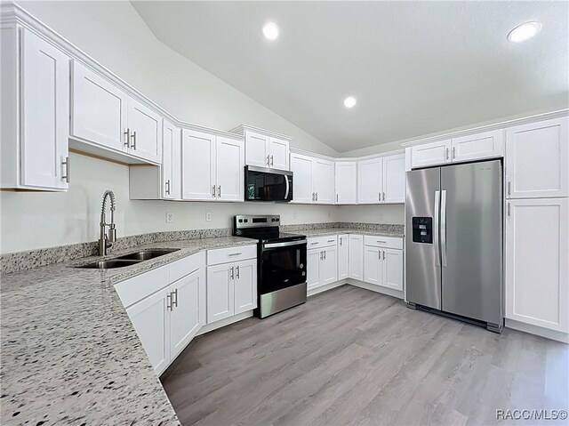 22777 SW Beach Blvd, Dunnellon, FL 34431 - kitchen featuring stainless steel appliances, a sink, vaulted ceiling, white cabinets, and recessed lighting